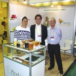 Stand da “Prodapys Organic Honey “ vendo-se da dir. p/esq. O Sr. Célio H. M. da Silva ao lado do Sr. Tarciano S. da Silva, ambos da Prodapys- de Araranguá-SC e um cliente.